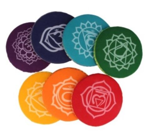 Stapel van zeven ronde meditatiekussens in regenboogkleuren, met een paarse bovenkant met het Om-symbool en gouden rand.