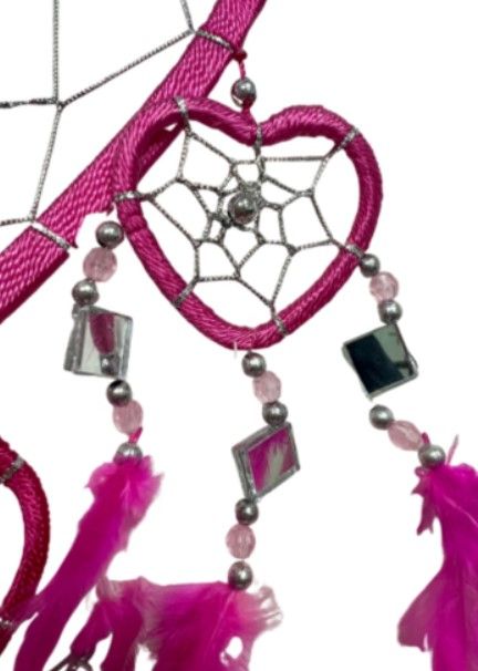 Roze dromenvanger in de vorm van een hart, met veren en kralen.