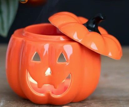 Een pompoen met deksel, verlicht met een gloeiend gezicht, staat op een griezelig bospad bij volle maan.