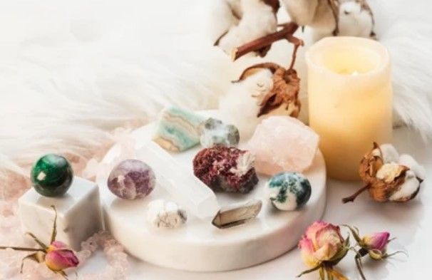 Arrangement van kristallen, kaars en bloemen op Seleniet