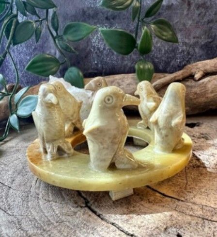 Gesneden stenen ring met zes kleine pinguïnfiguren erop.