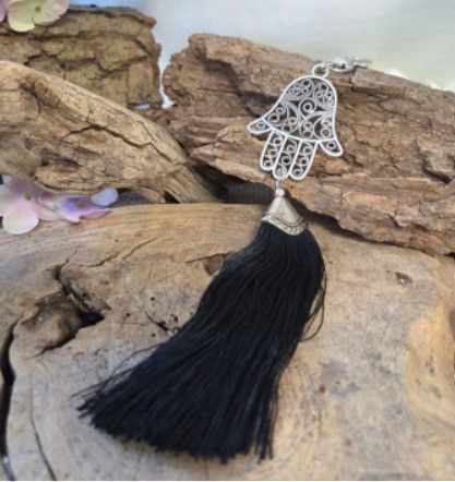 Zwarte sleutelhanger met kwastje, zilveren Hamsa hand en sluiting.