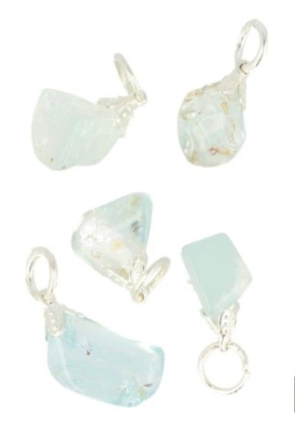 Oorbellen van aquamarijnkristal op een kwartscluster en een houten oppervlak.