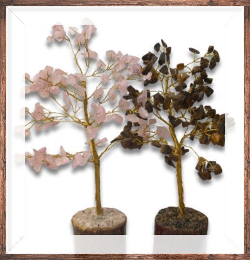 Twee decoratieve bomen met edelstenen en takken van gouddraad, één roze en één bruin, in een houten frame.