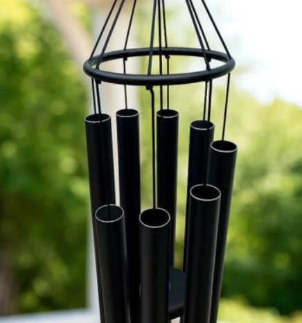 Zwarte windgong hangt op een witte achtergrond.