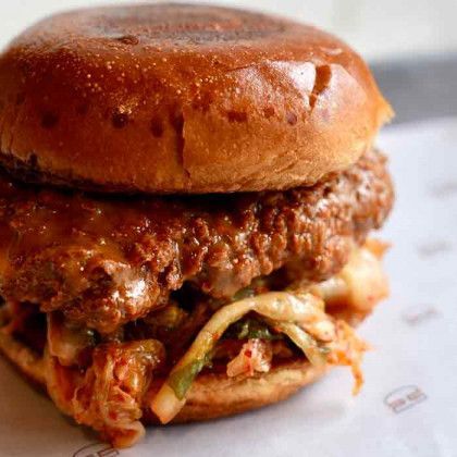 A close up of a chicken sandwich on a bun on a table.