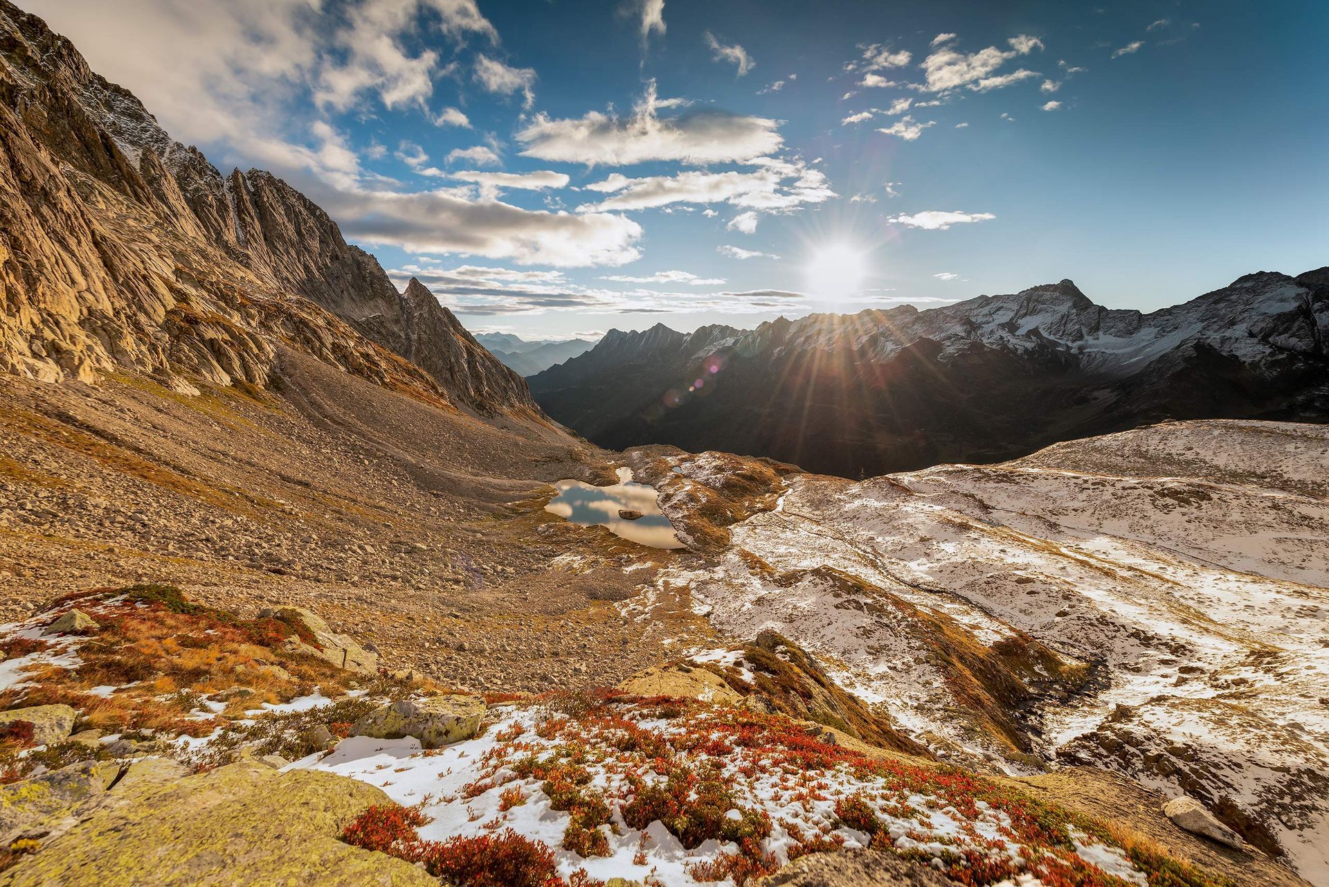 Il sole splende attraverso le nuvole sopra le montagne