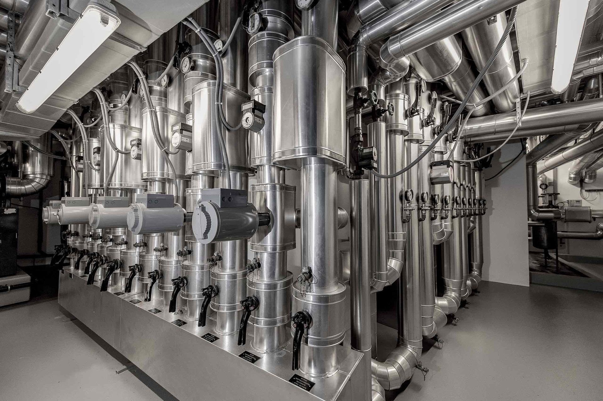 Una stanza piena di tanti tubi e valvole di metallo.