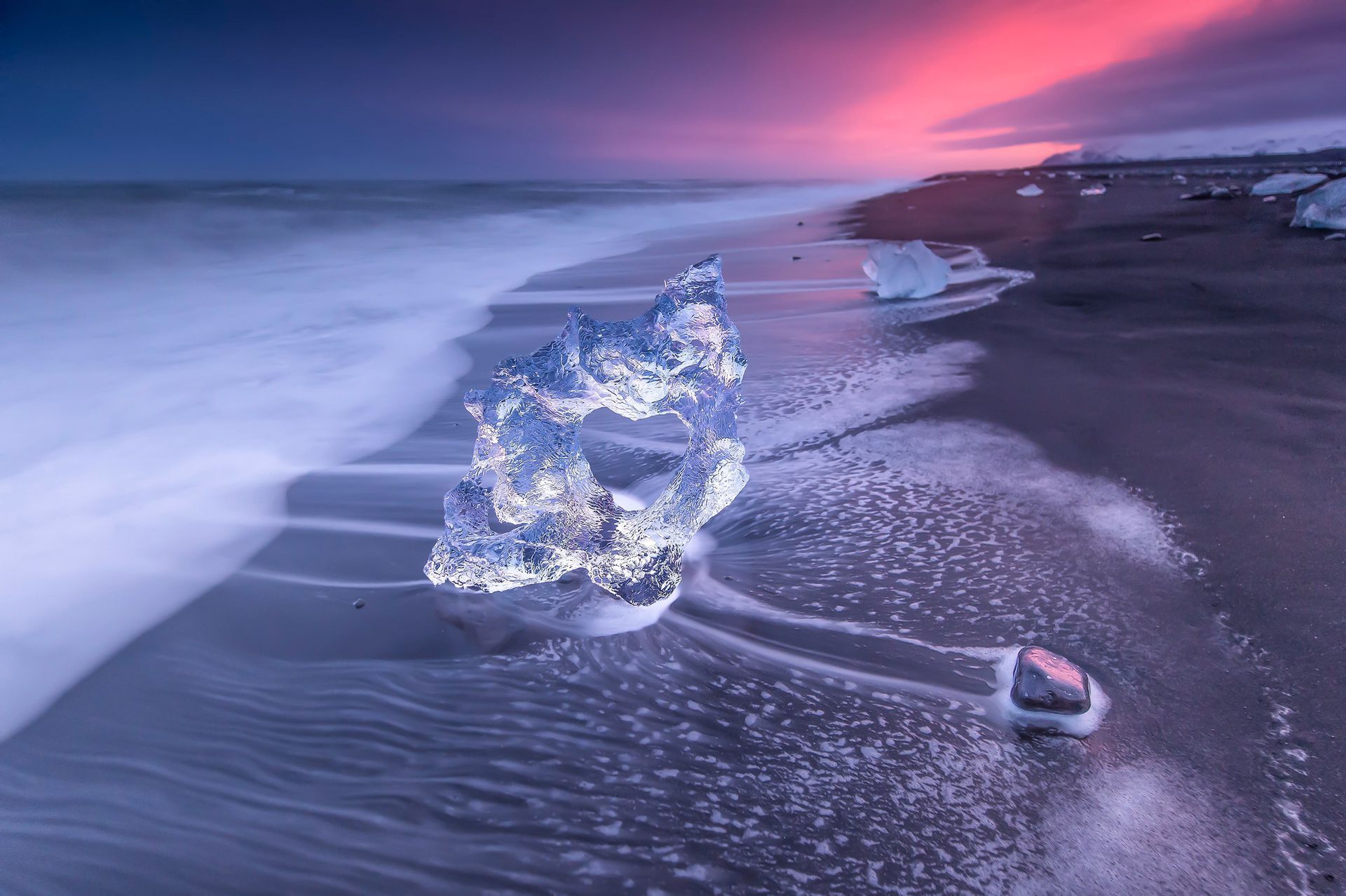 Un grande pezzo di ghiaccio galleggia sulla spiaggia vicino all'oceano in Islanda.