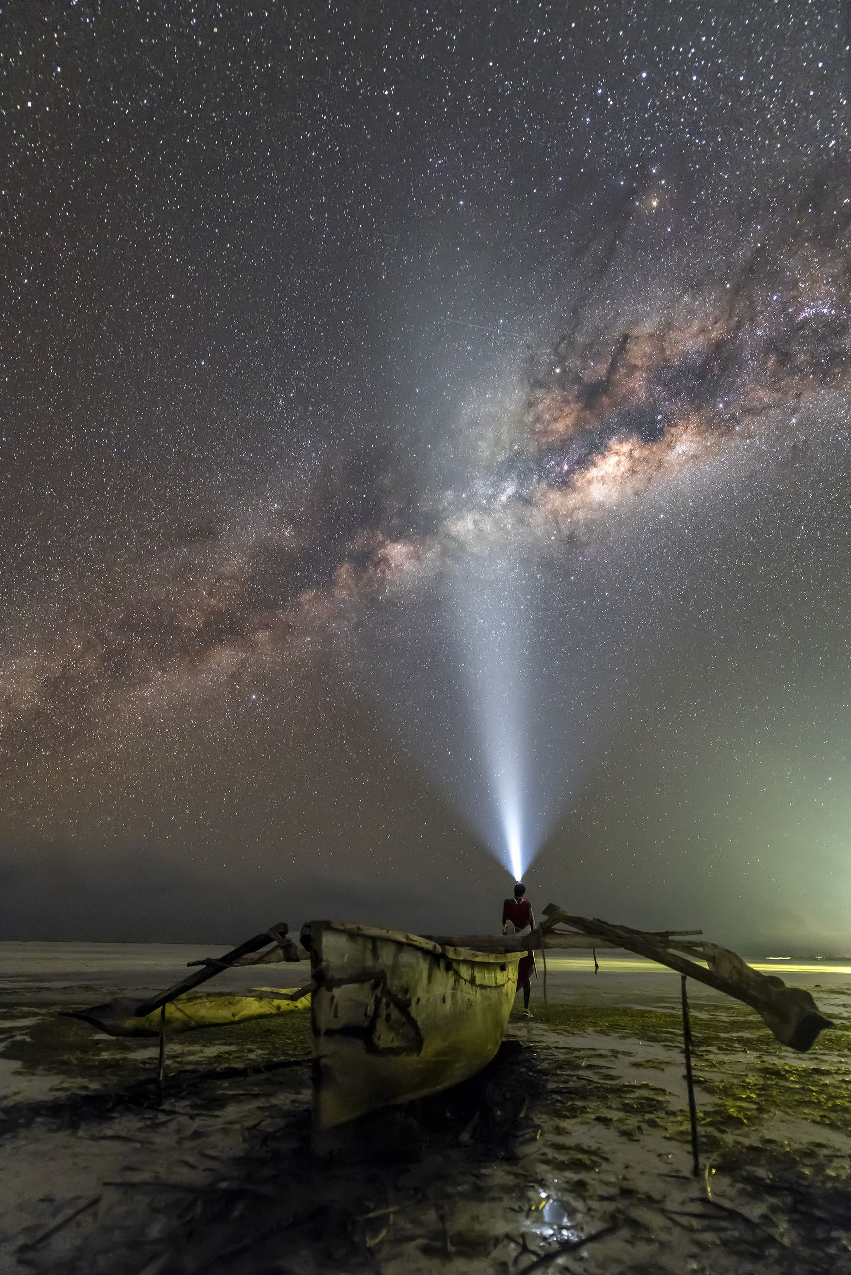 Una persona è in piedi su una barca sotto un cielo stellato