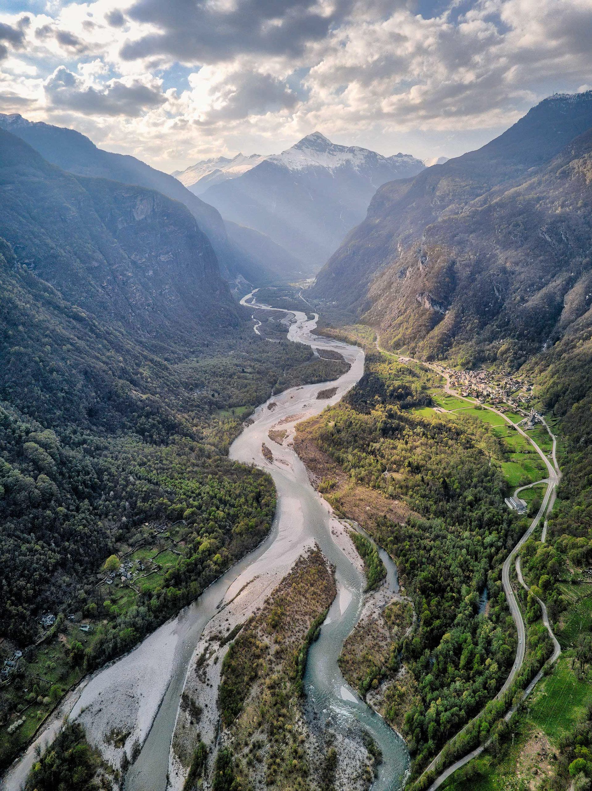 Una veduta aerea di un fiume che scorre attraverso una valle circondata da montagne.