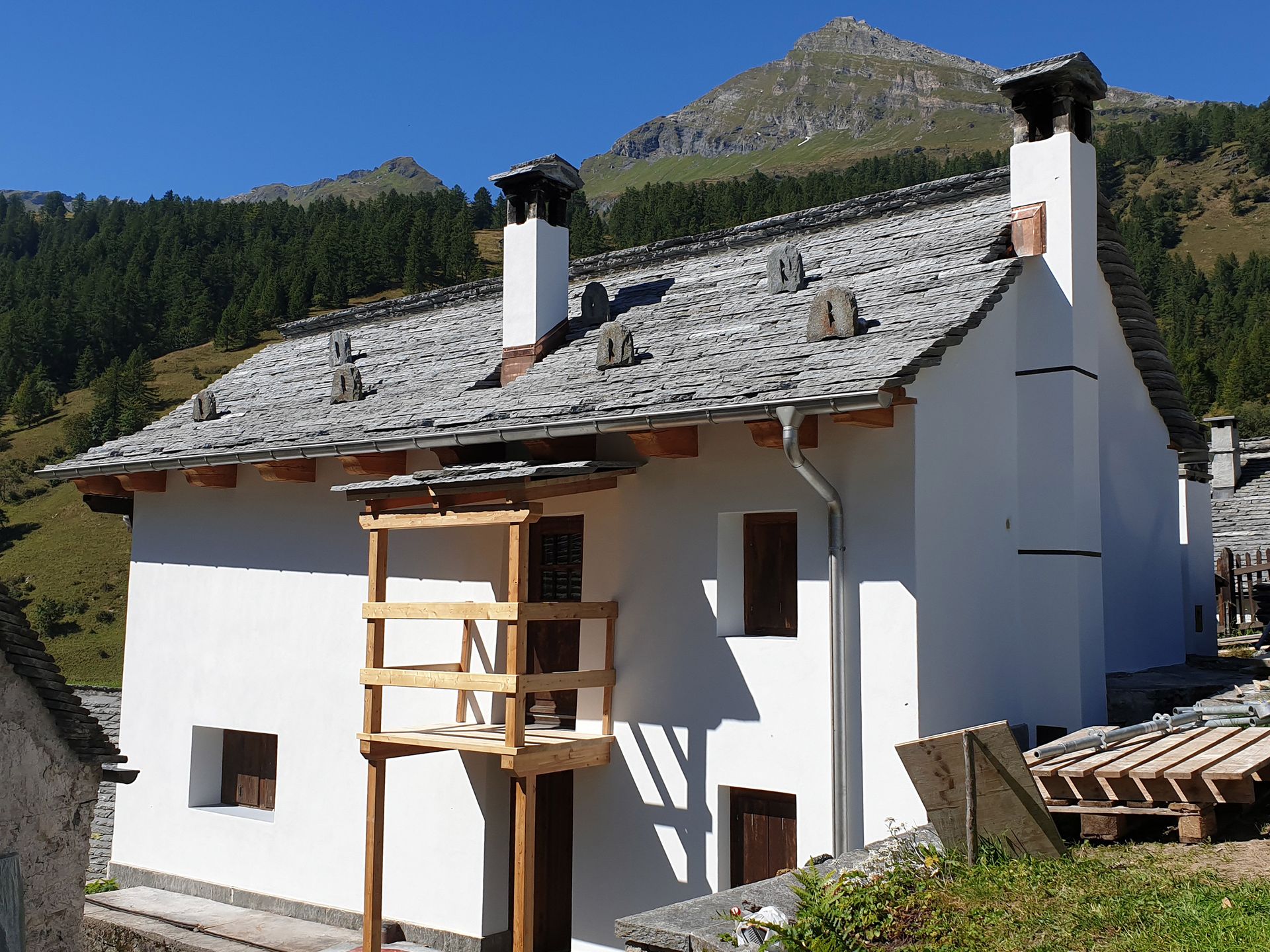 Una casa bianca con una montagna sullo sfondo