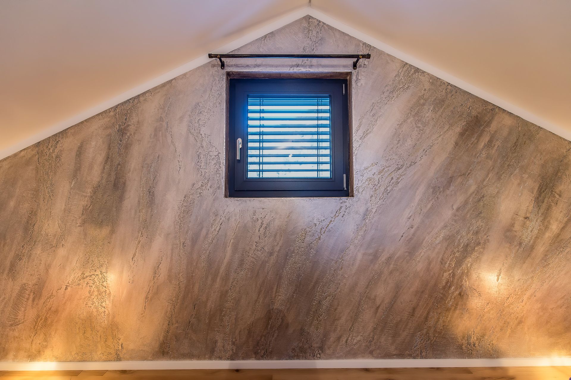 Una soffitta con finestra e persiane