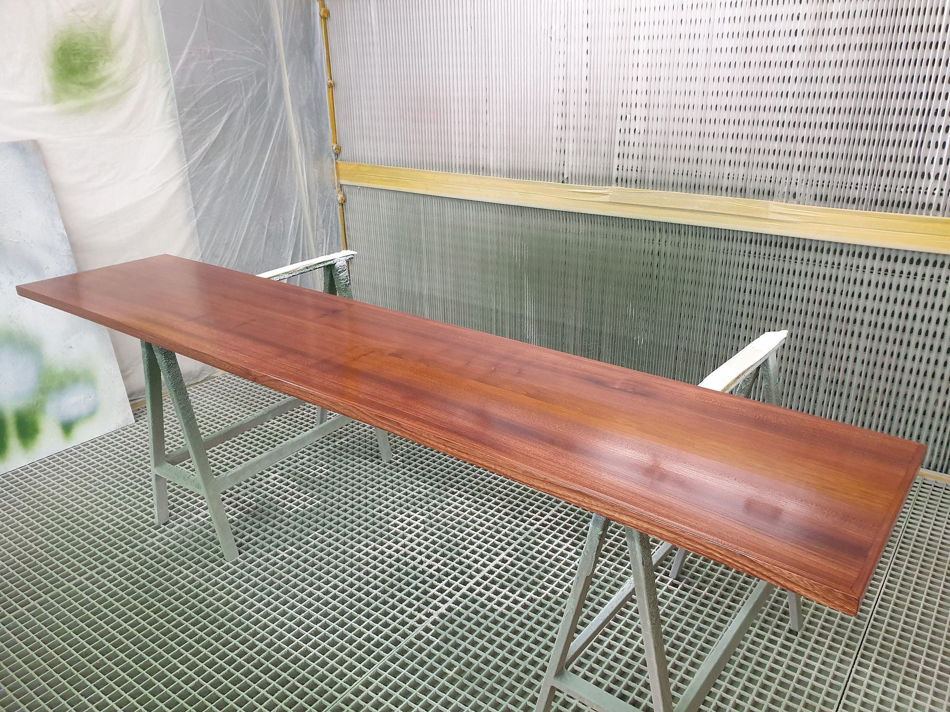 Un lungo tavolo di legno è seduto su un supporto di metallo in una stanza.