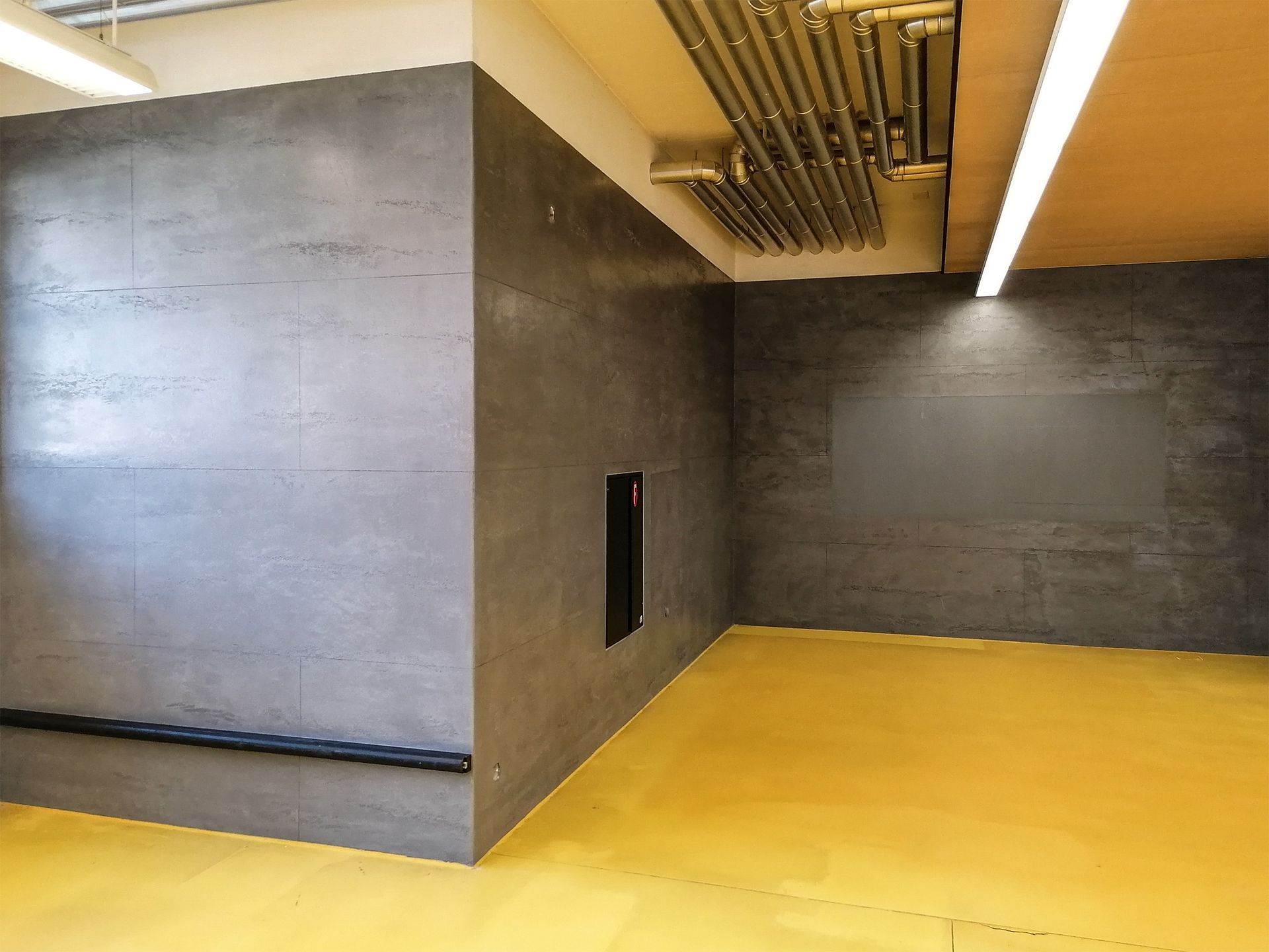 Una stanza con il pavimento giallo e il muro grigio