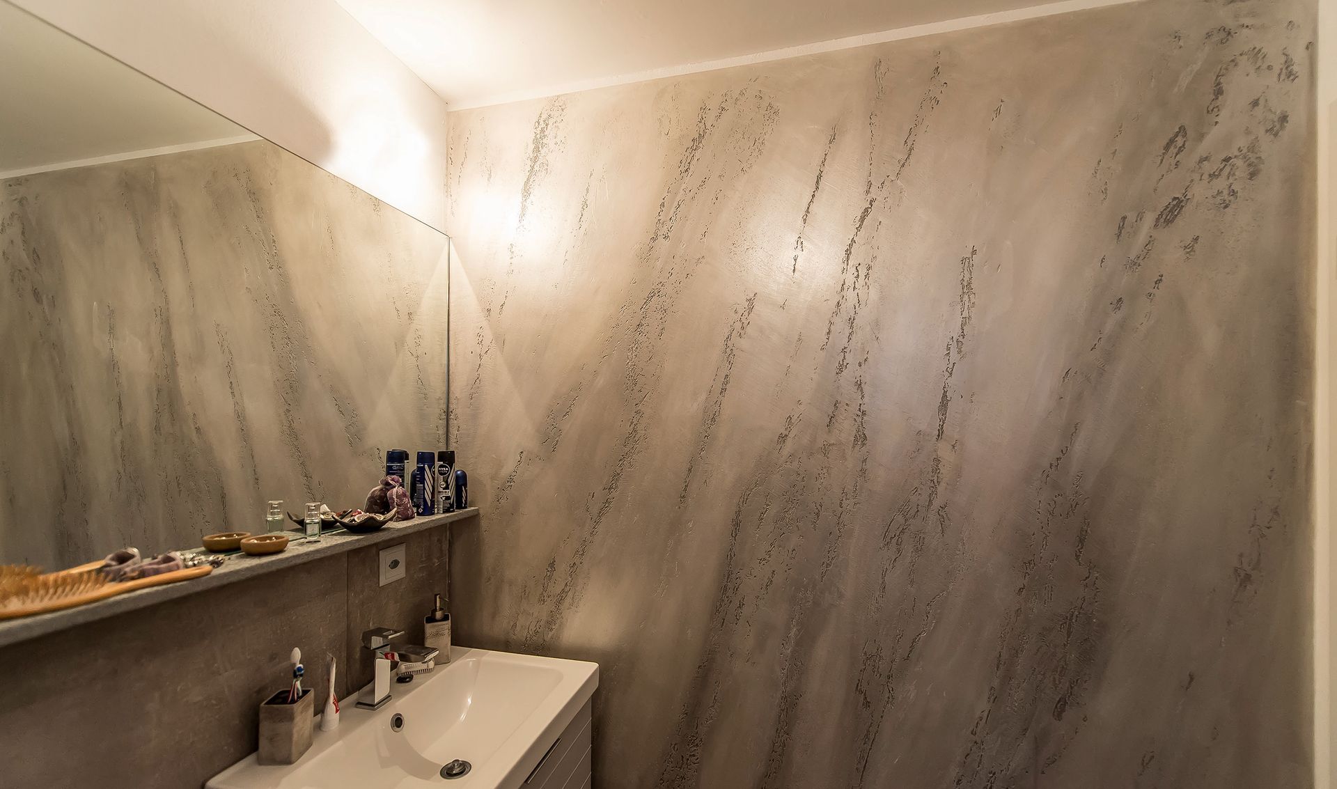 Un bagno con lavabo, specchio e mensola.