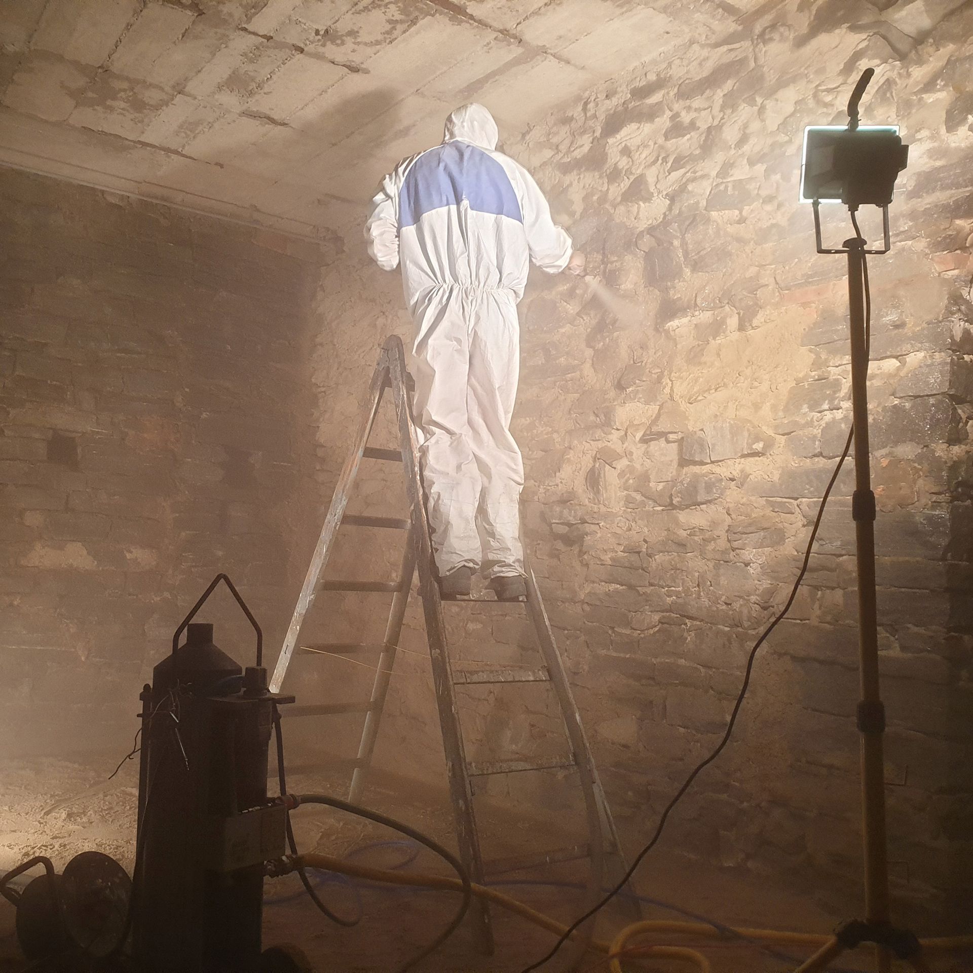 Un uomo con una tuta protettiva è in piedi su una scala