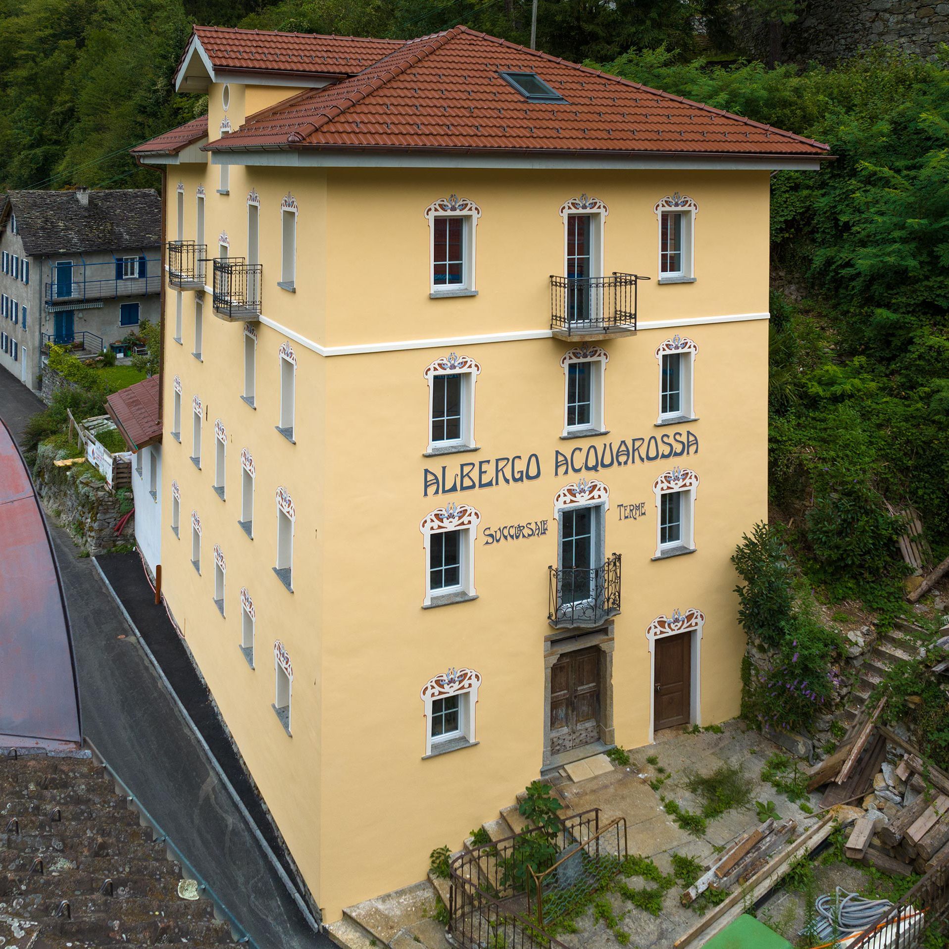 Una veduta aerea di un edificio giallo con sopra la scritta albergo