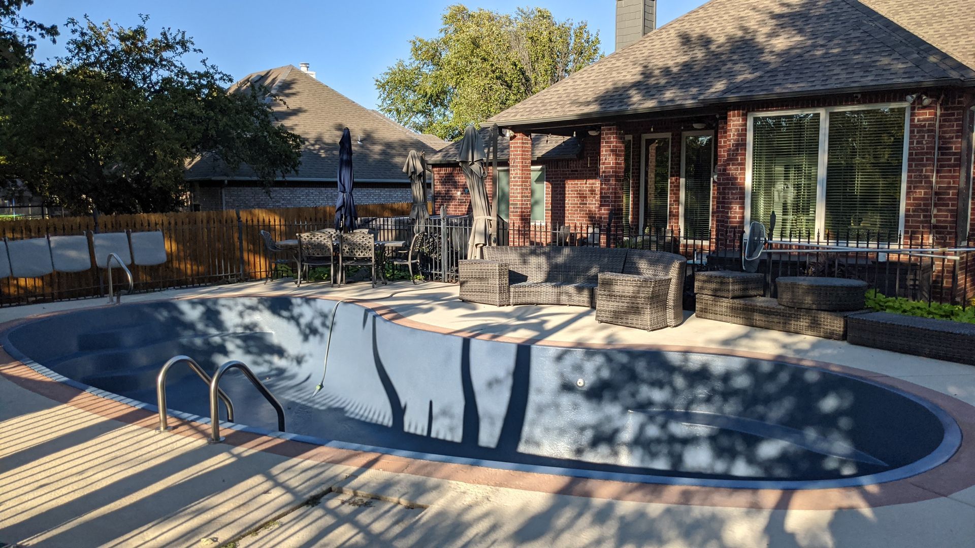 Blue inflatable shark and pink donut float in a clear blue pool.