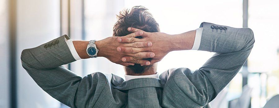 Business man relaxing with his hands behind his head | Omega Tech Property LLC