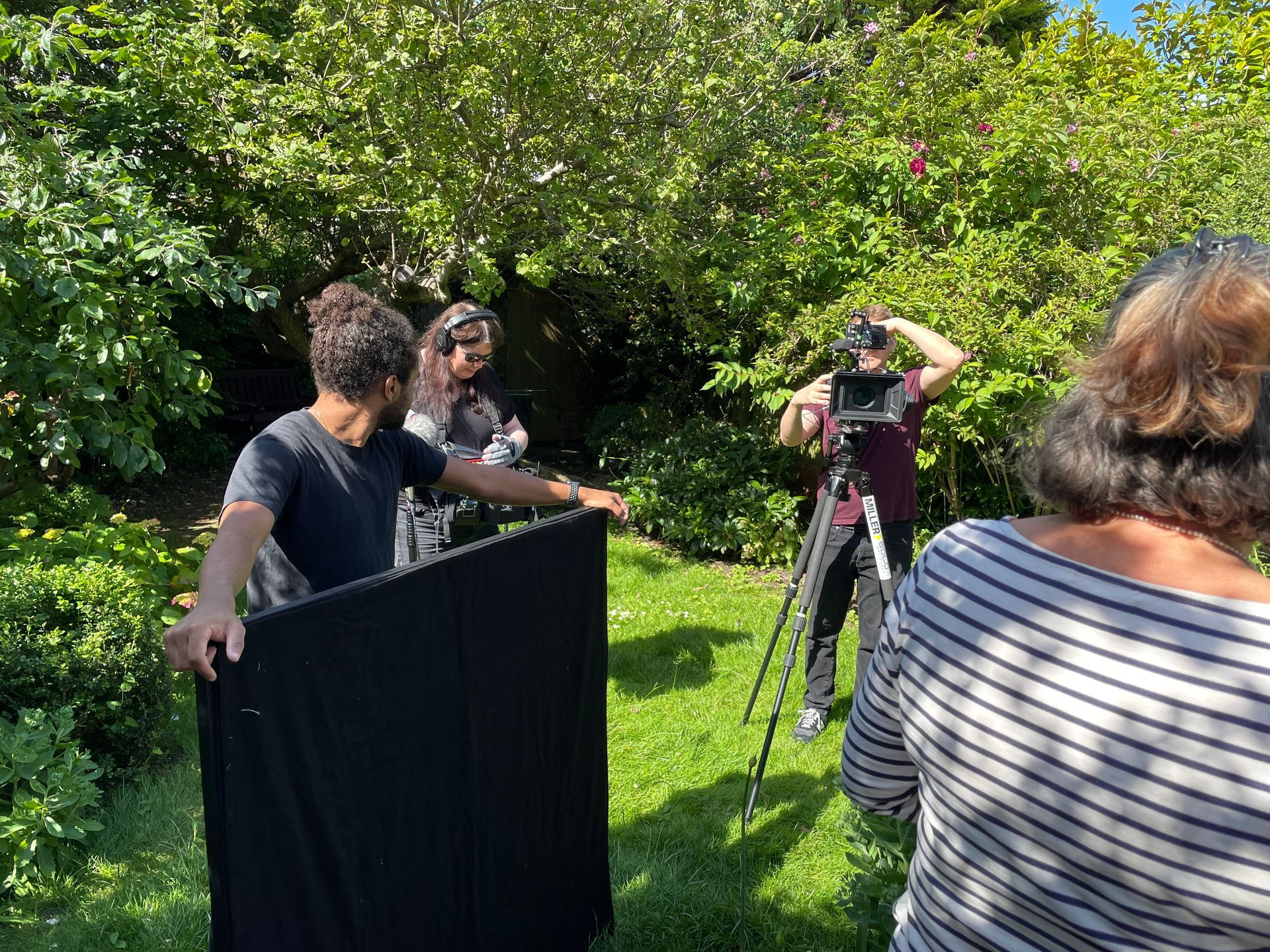 A film crew in a garden.