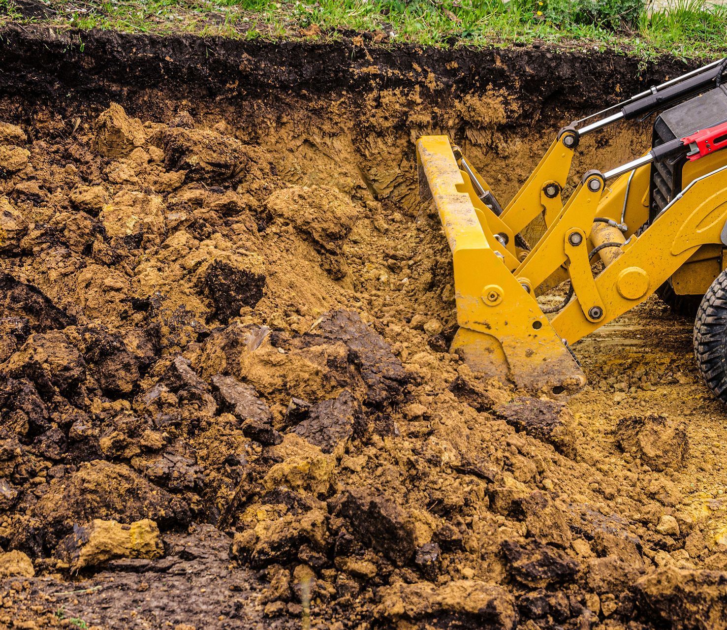 An Excavator Is Loading Dirt Into A Dump Truck — Glen Tier Bobcat & Truck Hire In Woree, QLD