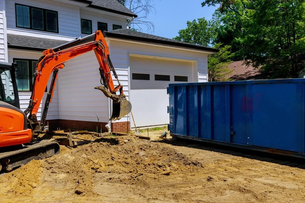 An Excavator Is Digging A Hole In The Dirt In Front Of A House — Glen Tier Bobcat & Truck Hire In Woree, QLD