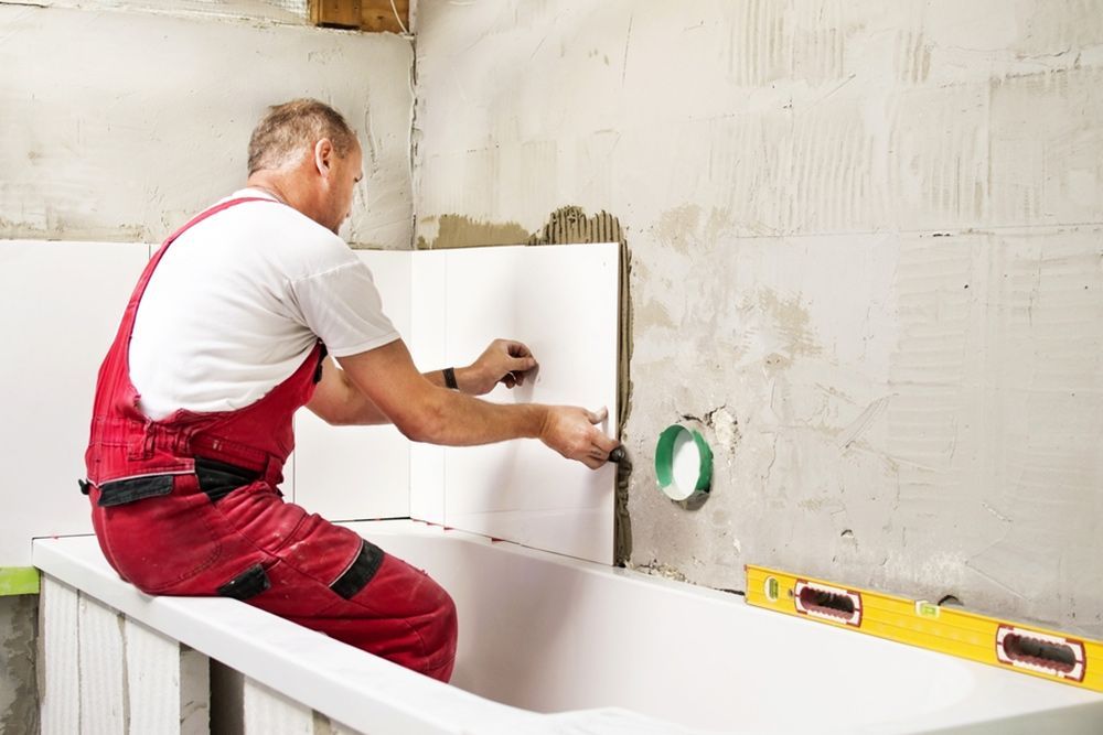 Man Finishing the Tiles in the Bathroom — Bathroom Renovation in Gladstone Region, QLD