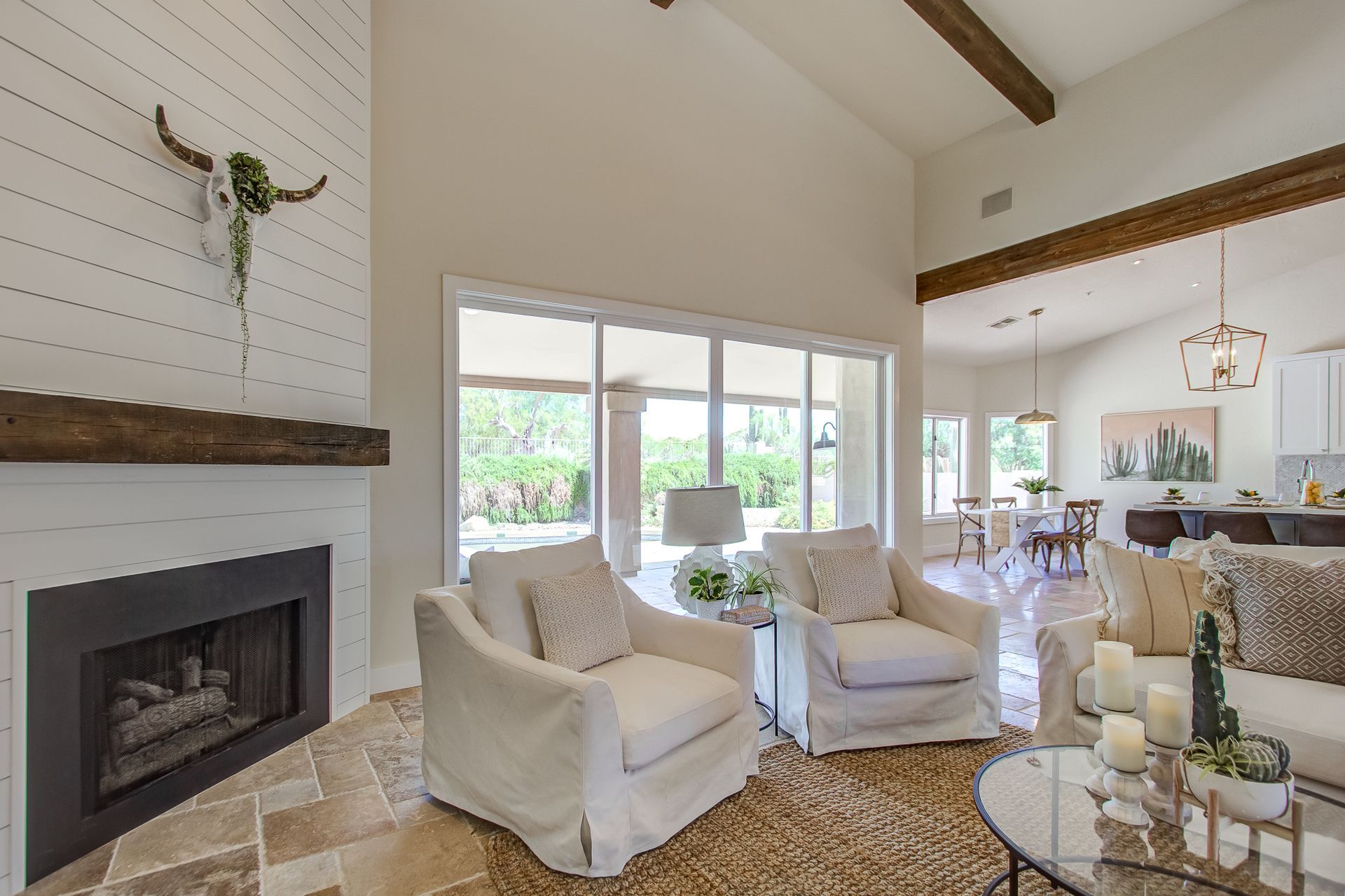 A living room with two white chairs and a fireplace
