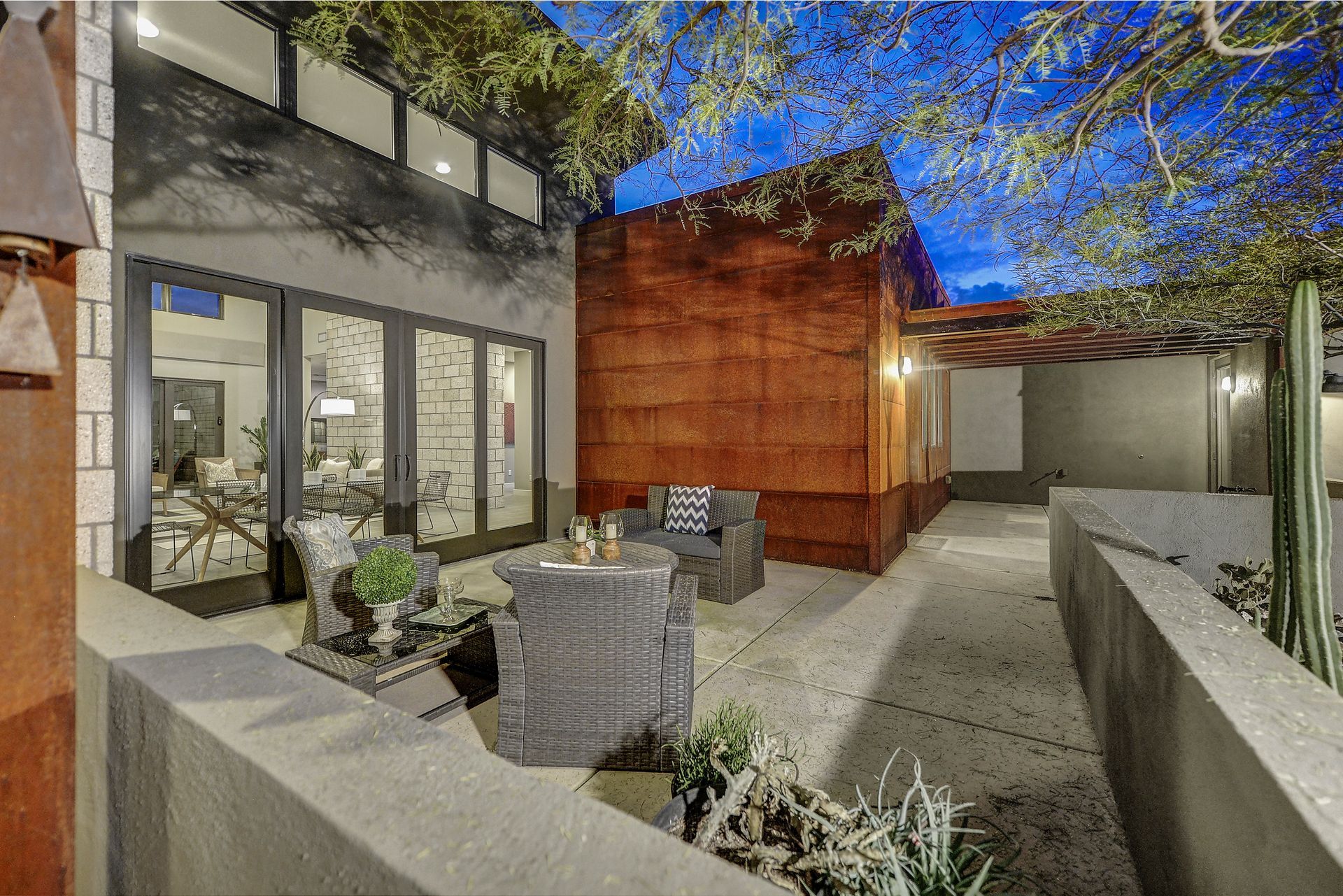 A patio with a table and chairs in front of a house.