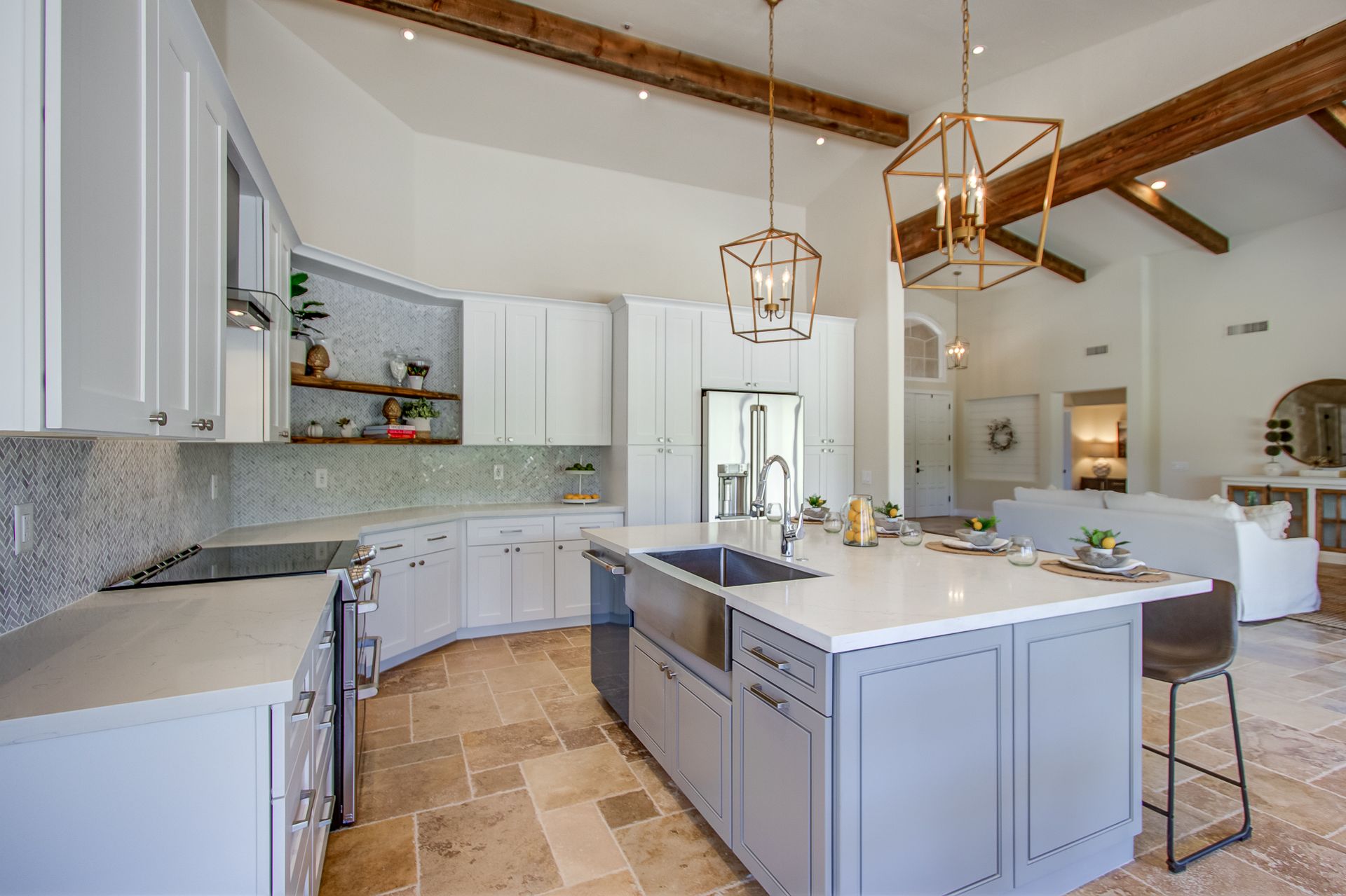 A kitchen with white cabinets and a large island in the middle.