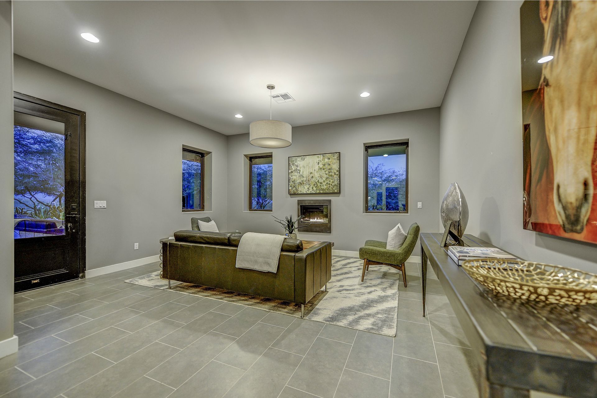 A living room with a couch , chairs , and a fireplace.