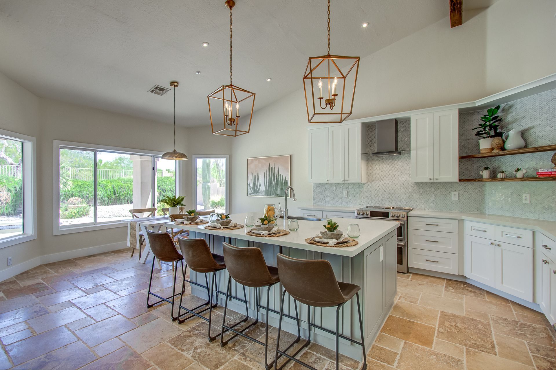 A kitchen with a large island , stools and a table.