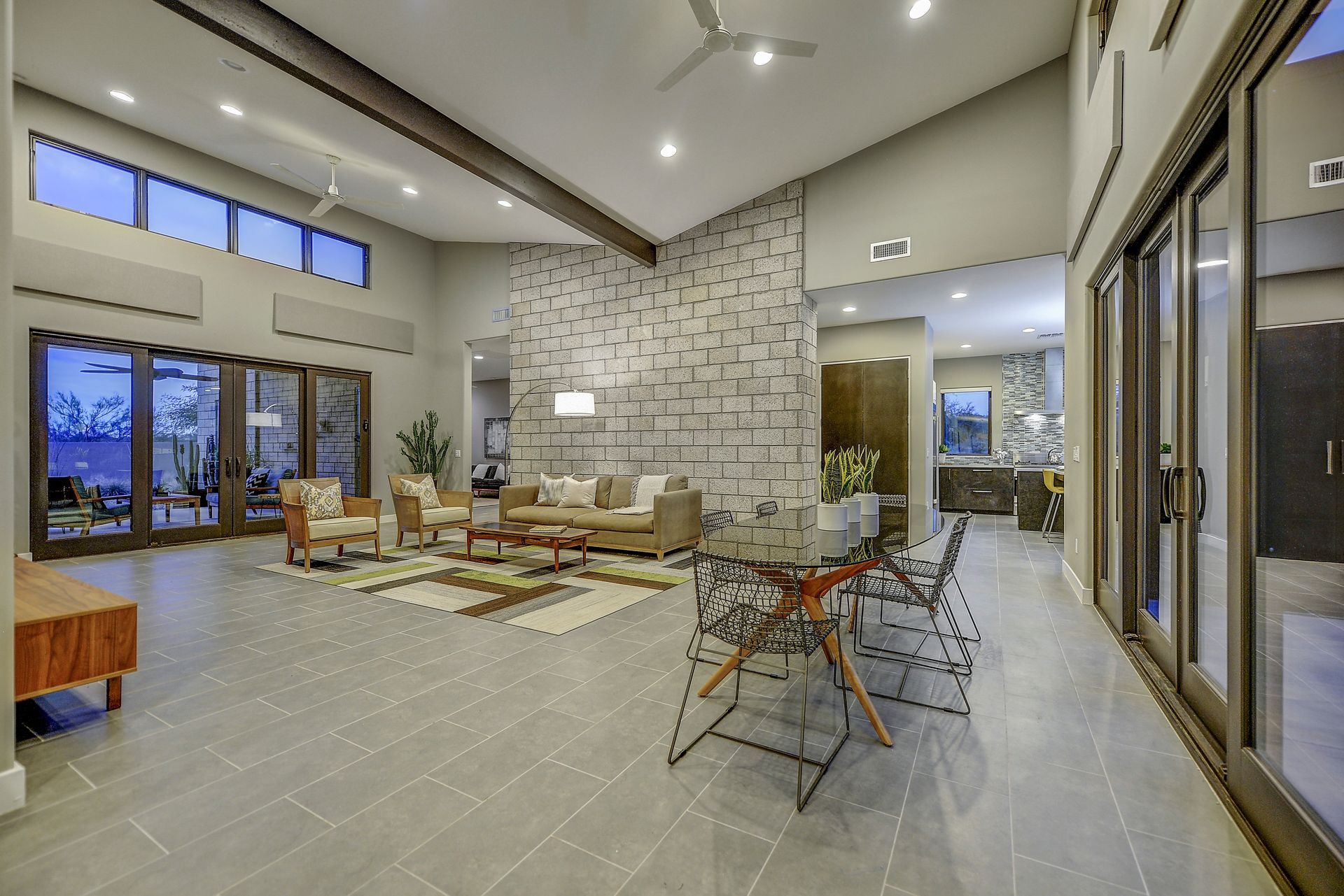 A living room with a couch , chairs , a table and a fireplace.