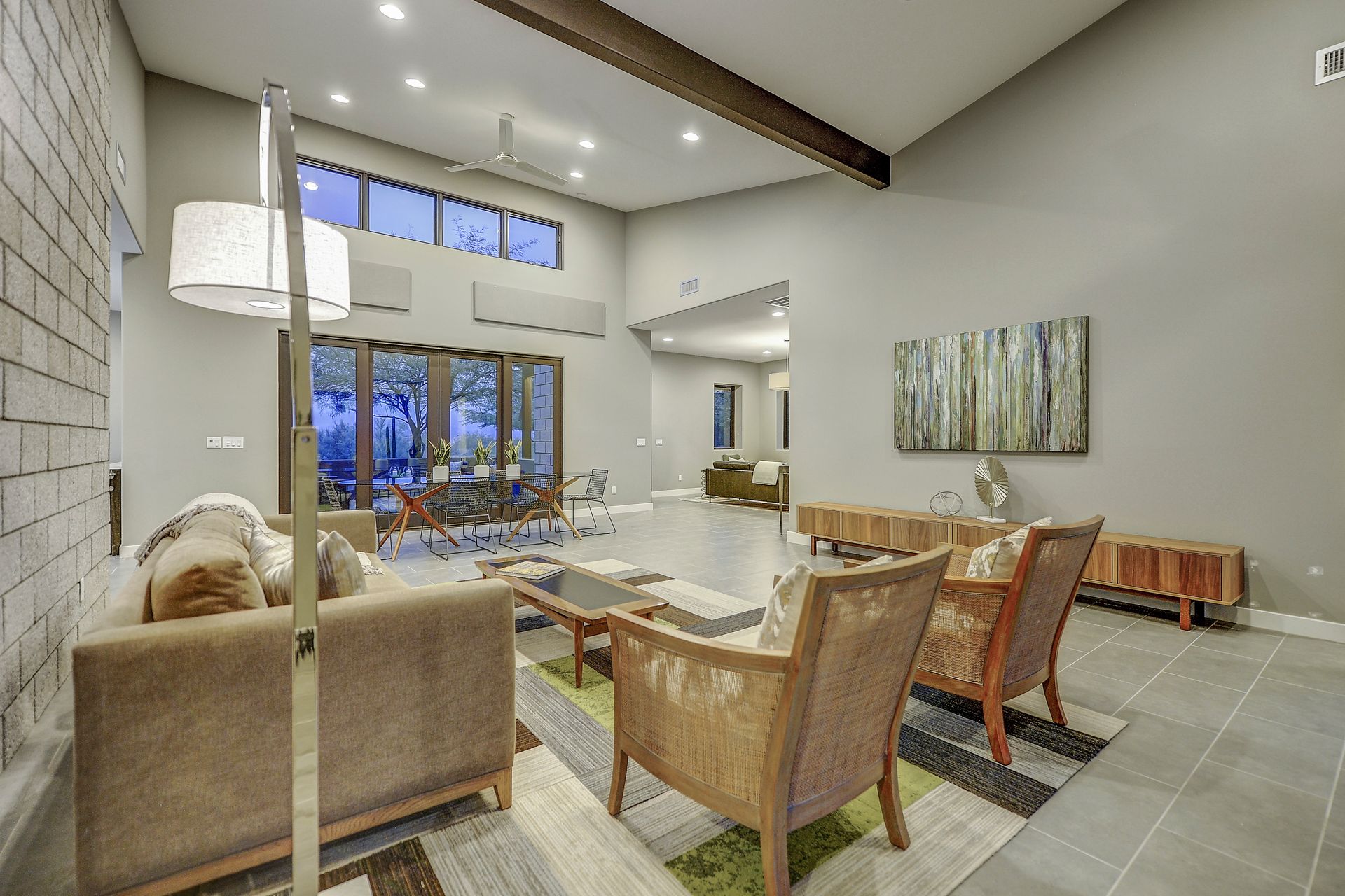 A living room with a couch , chairs , and a lamp.