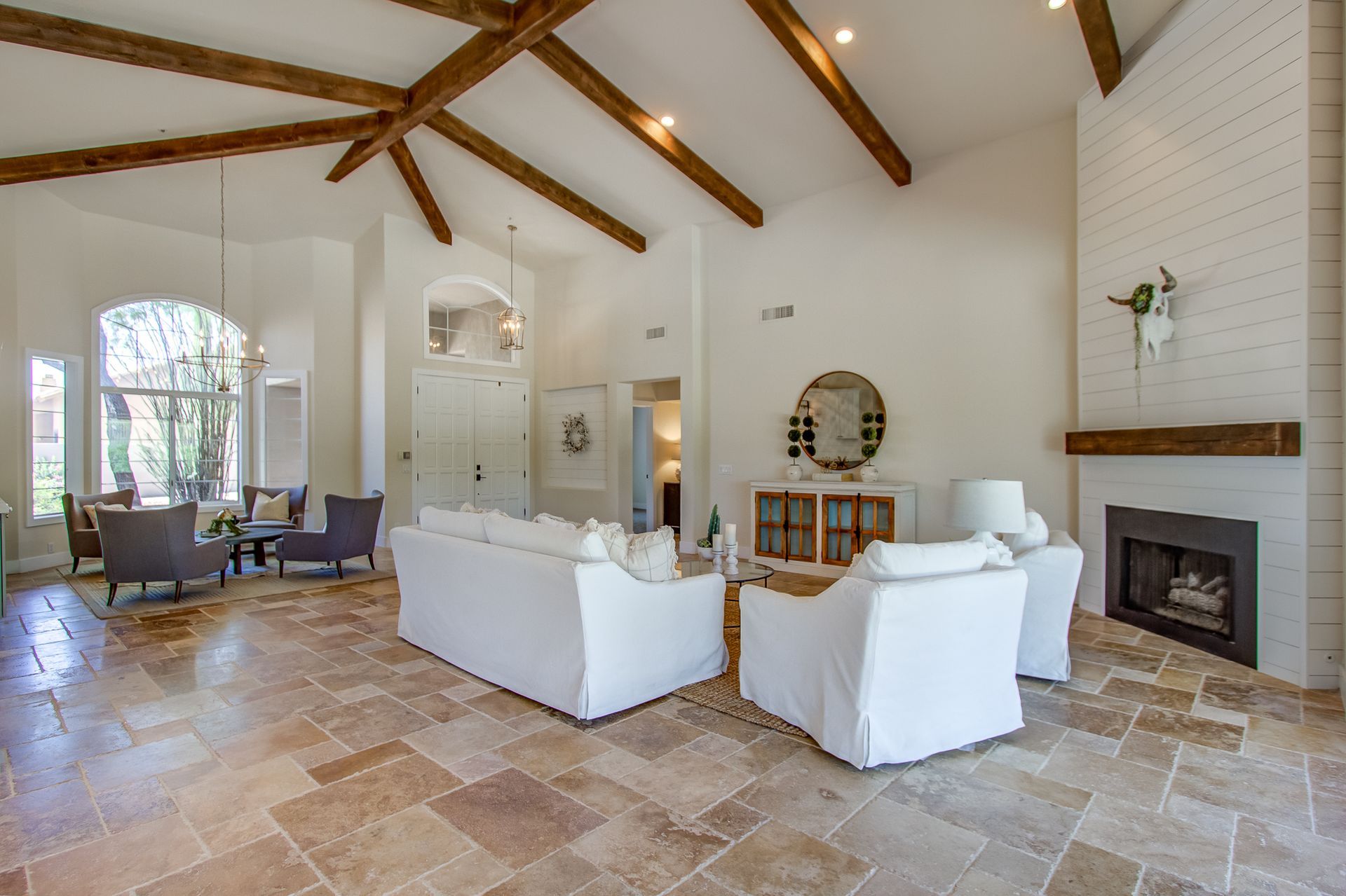 A living room with white furniture and a fireplace