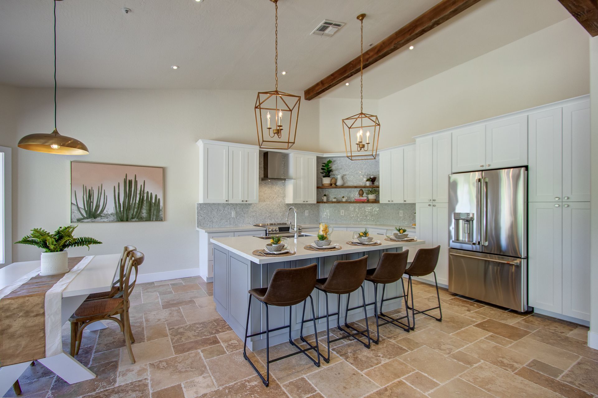A kitchen with white cabinets and stainless steel appliances and a large island.