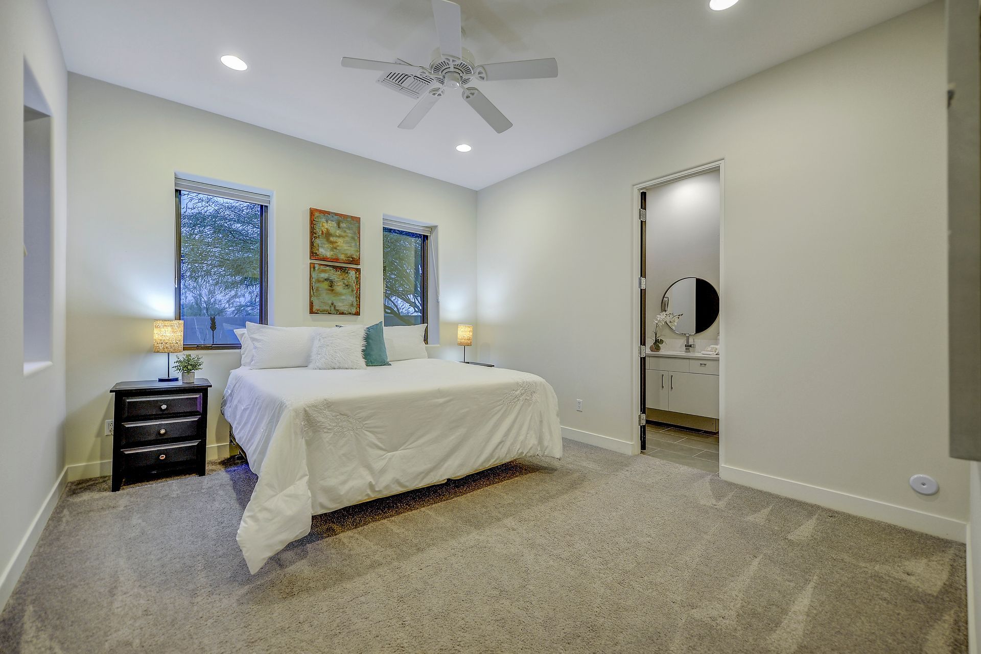 A bedroom with a king size bed and a ceiling fan.