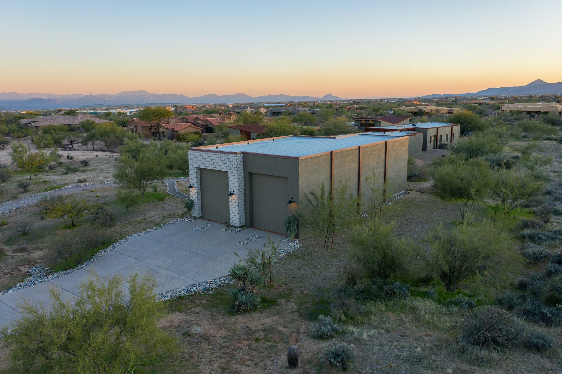An aerial view of a modern house in the middle of a desert.