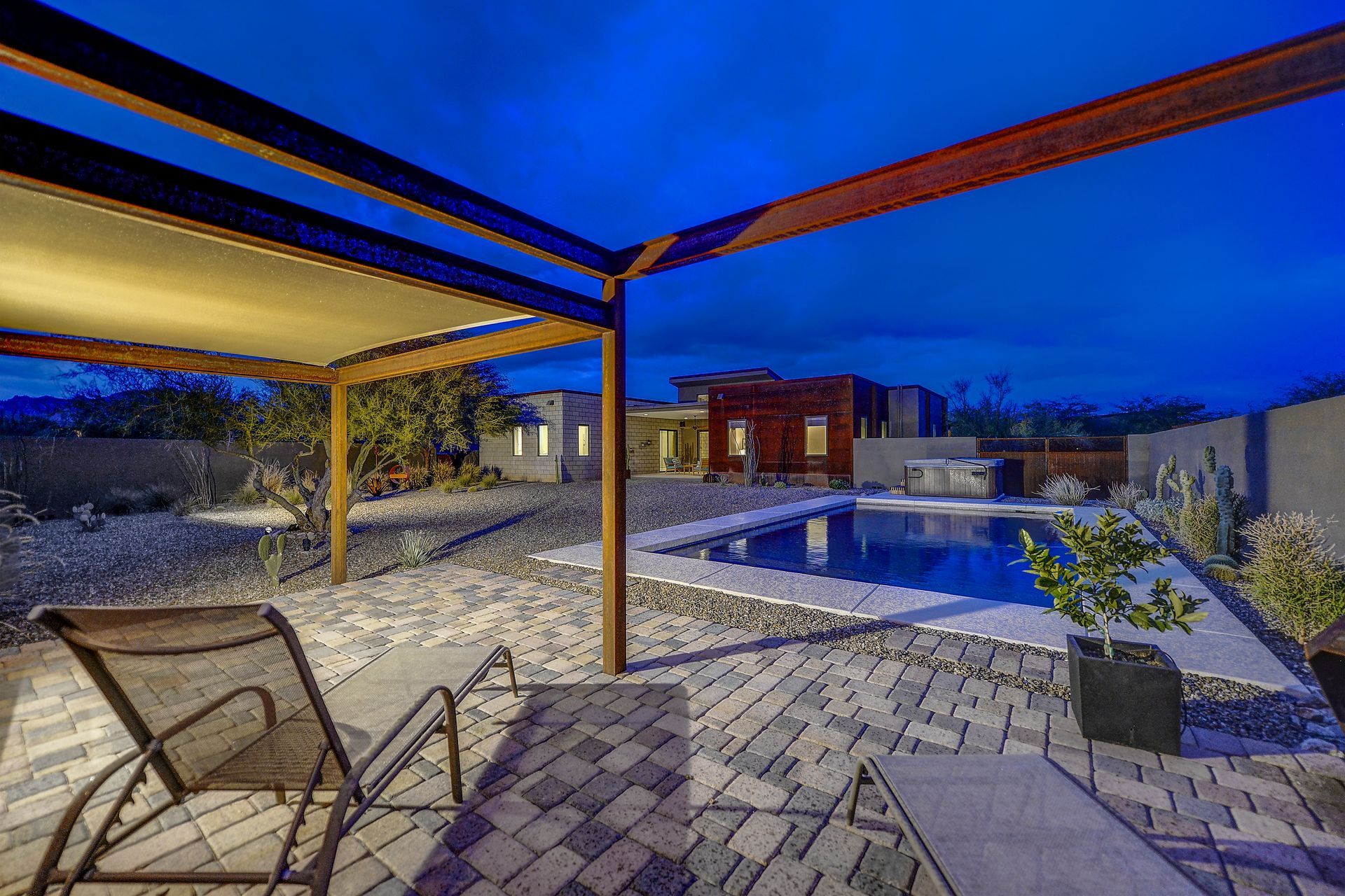 There is a swimming pool in the backyard of a house.