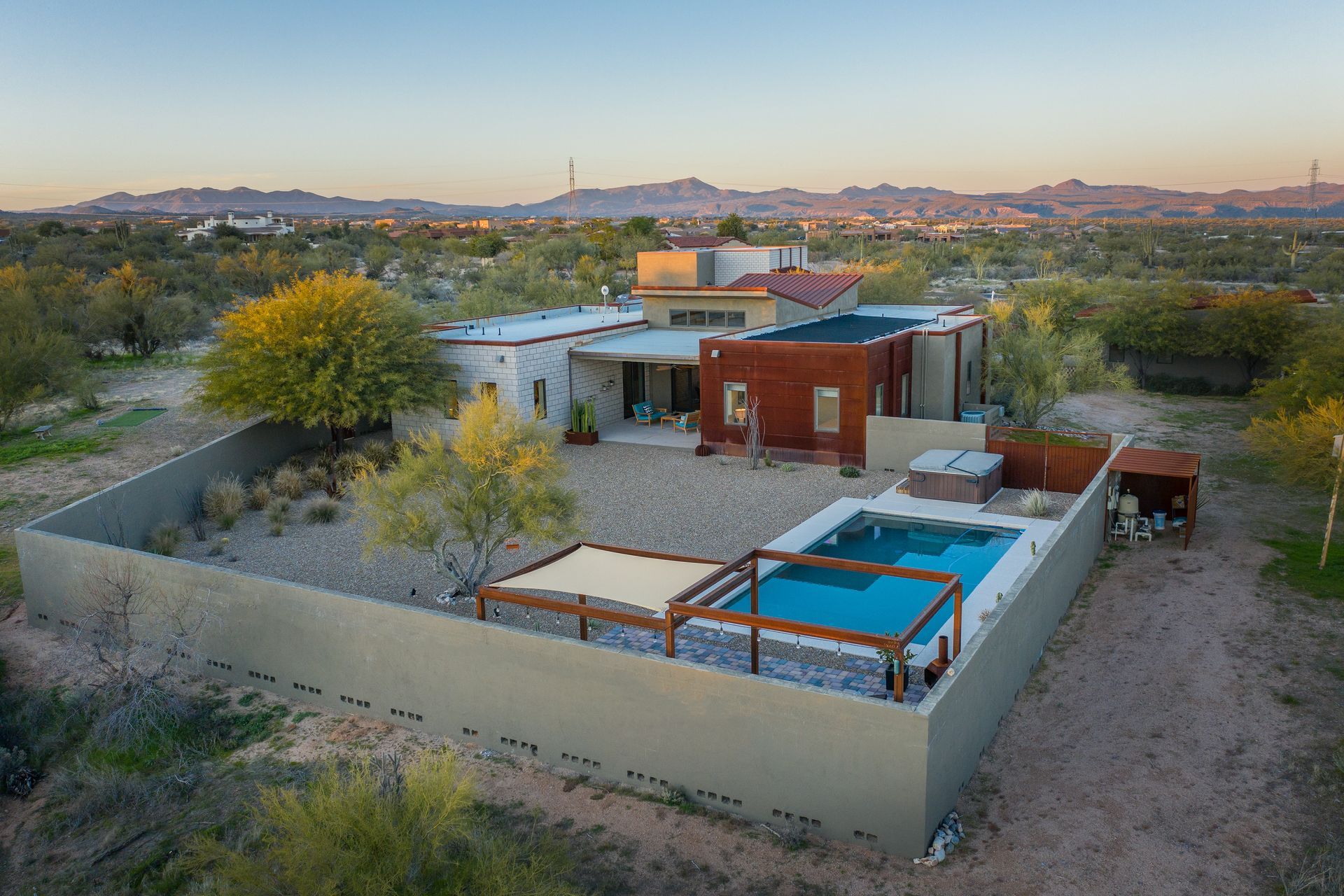 An aerial view of a house with a pool and mountains in the background.