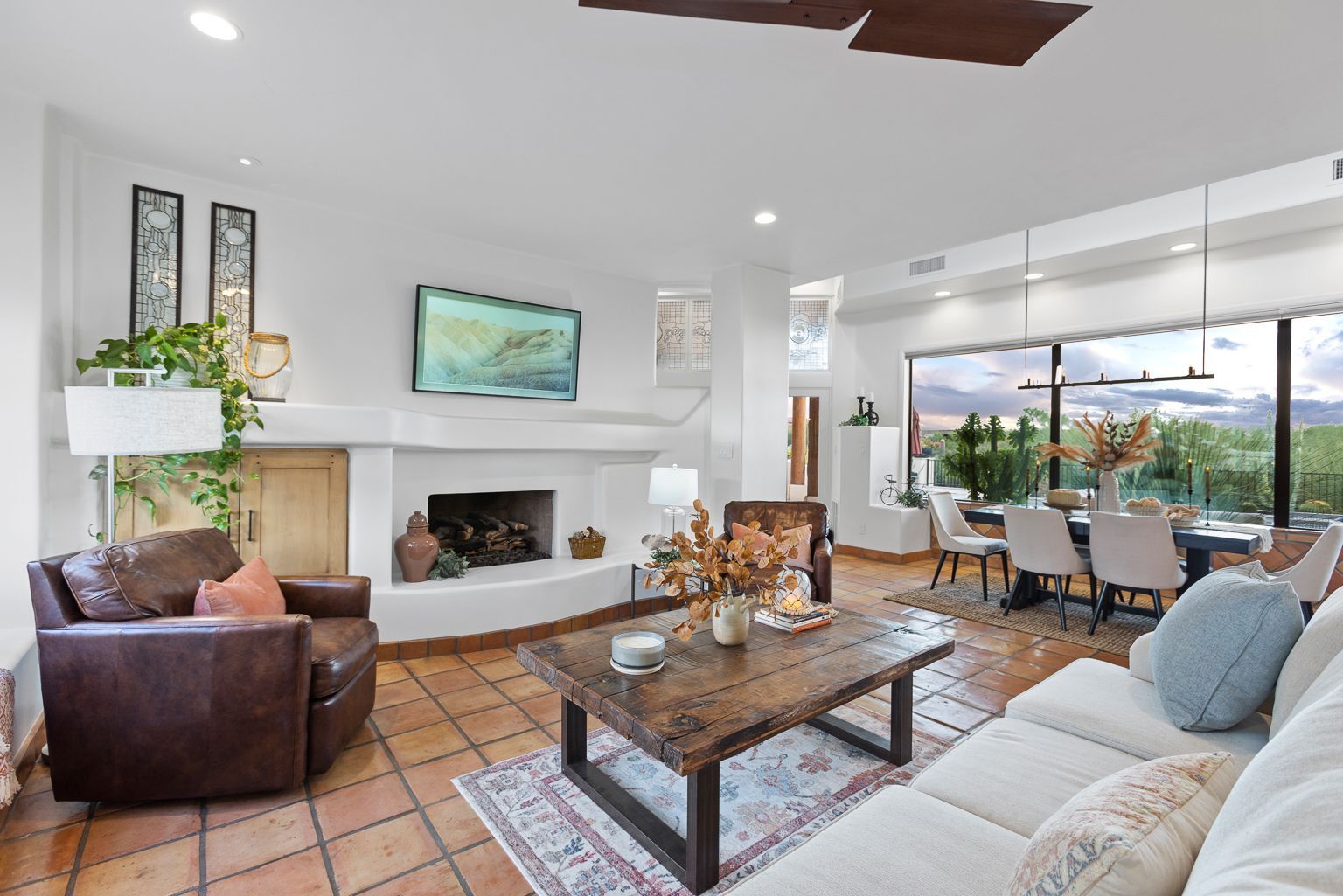 A living room with a couch , chair , coffee table and fireplace.
