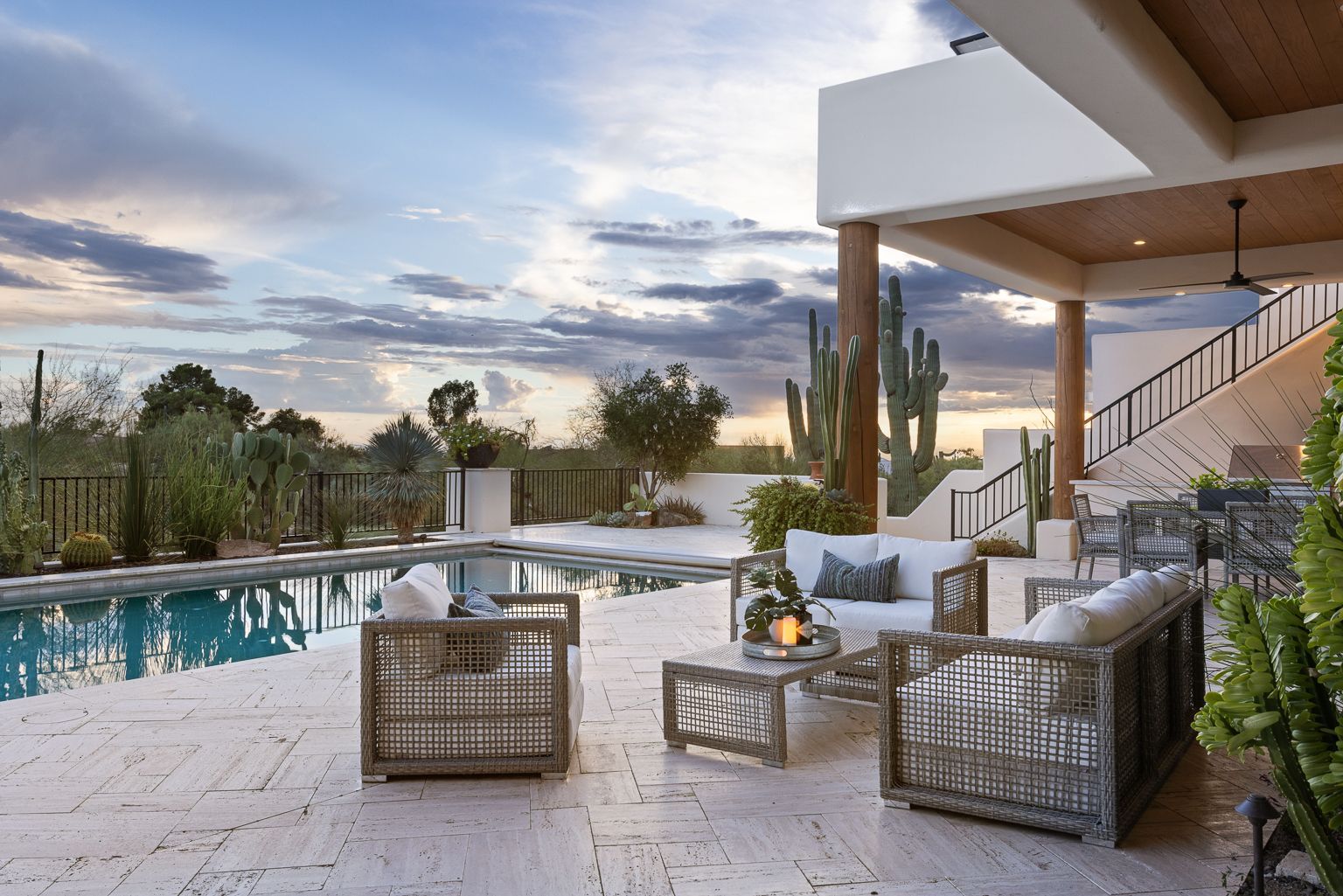 A patio with furniture and a swimming pool in the background