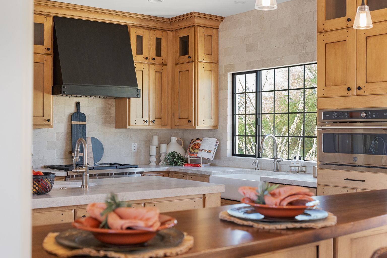 A kitchen with wooden cabinets , stainless steel appliances , a sink , and a window.