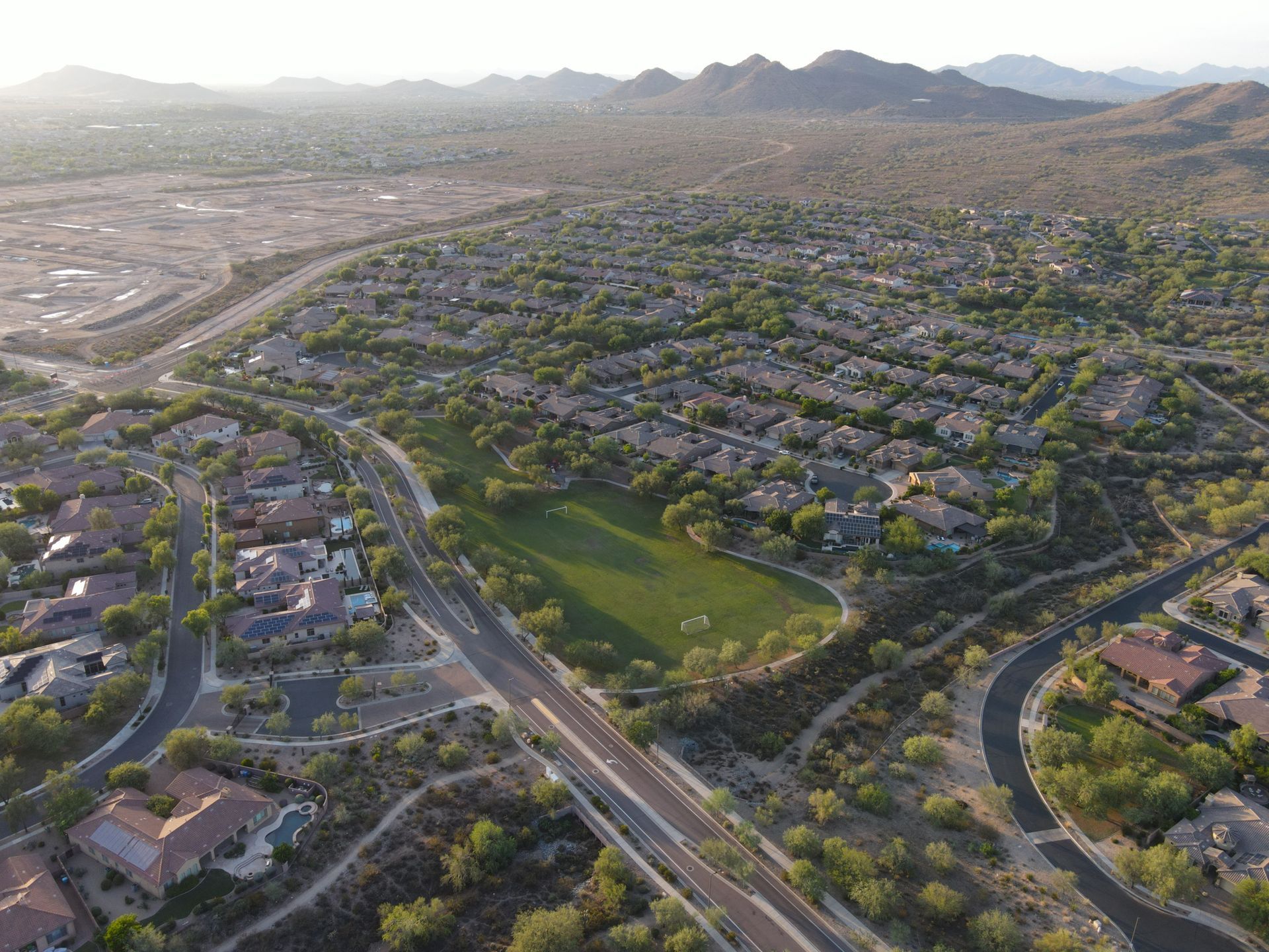 An aerial view of a residential area with mountains in the background.