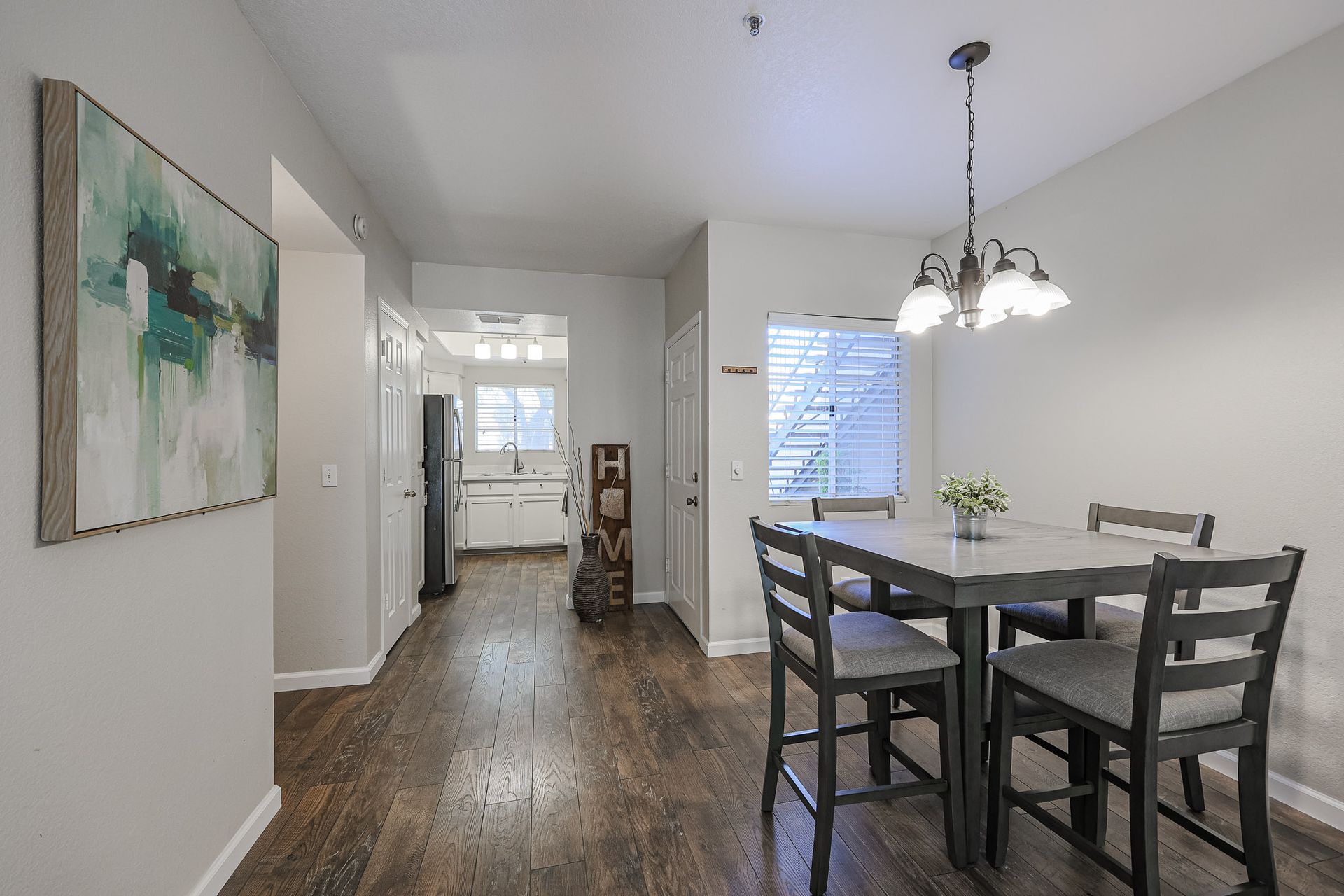 A dining room with a table and chairs and a chandelier.