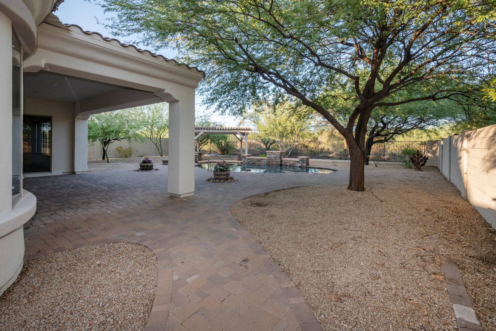 The backyard of a house with a tree and a pool