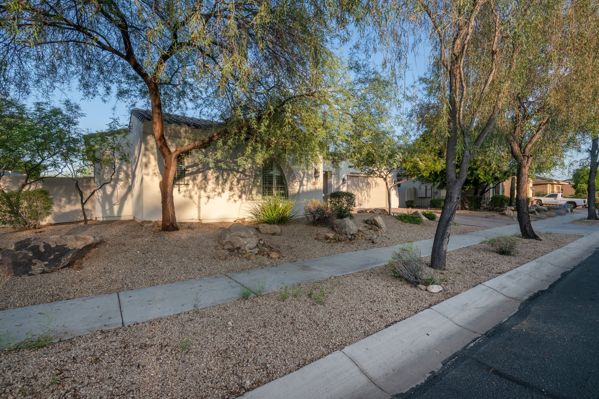 A house with a sidewalk and trees in front of it