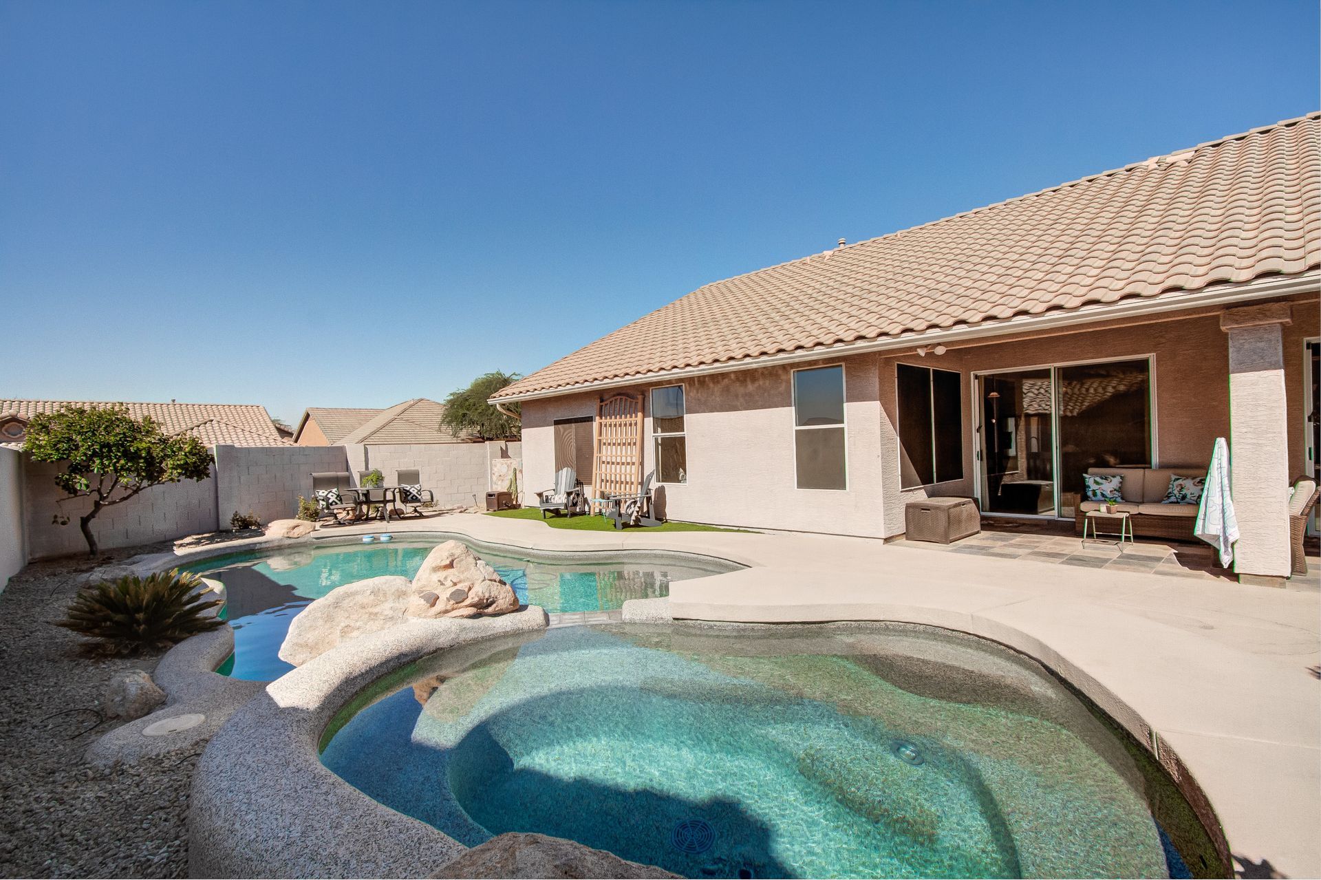There is a large swimming pool in the backyard of a house.