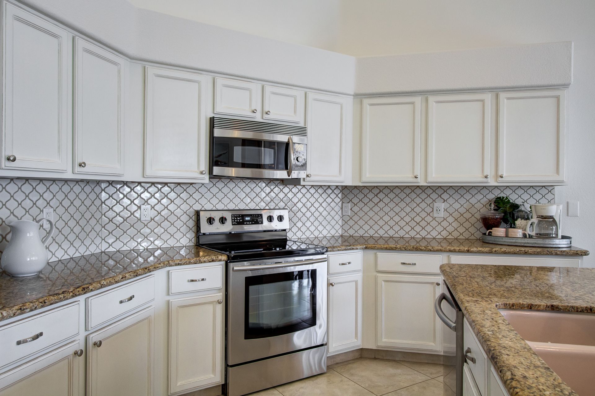 A kitchen with white cabinets and stainless steel appliances